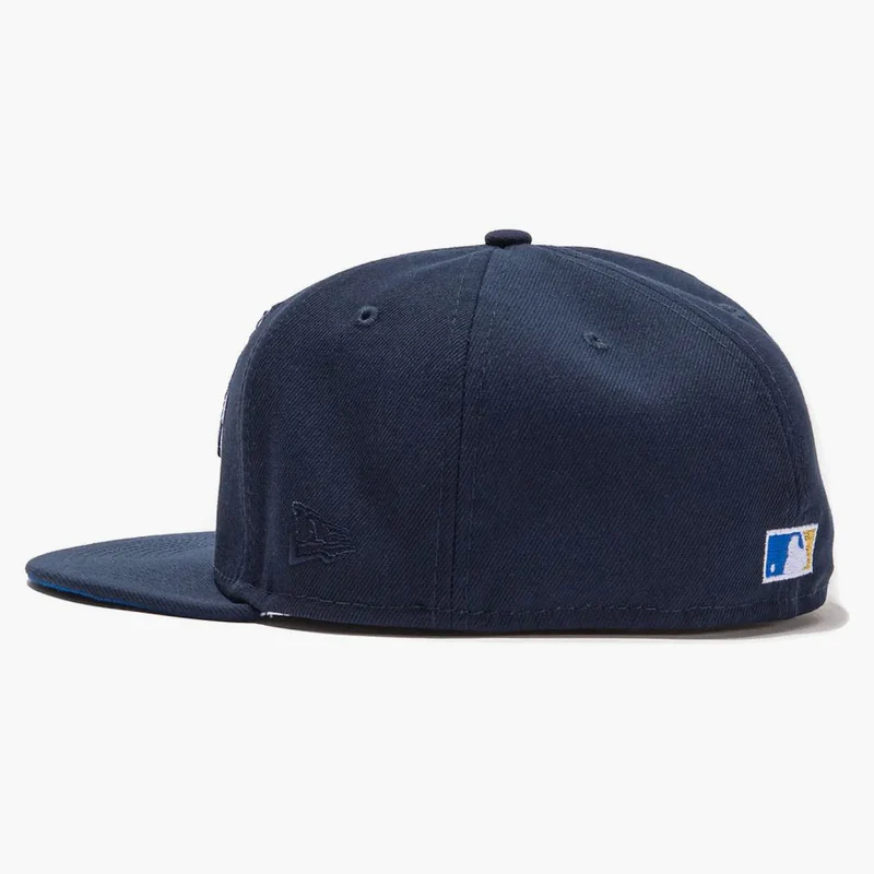 Side profile of the St. Louis Cardinals navy fitted hat showing a tonal embroidered New Era flag and the MLB Batterman logo on the back.