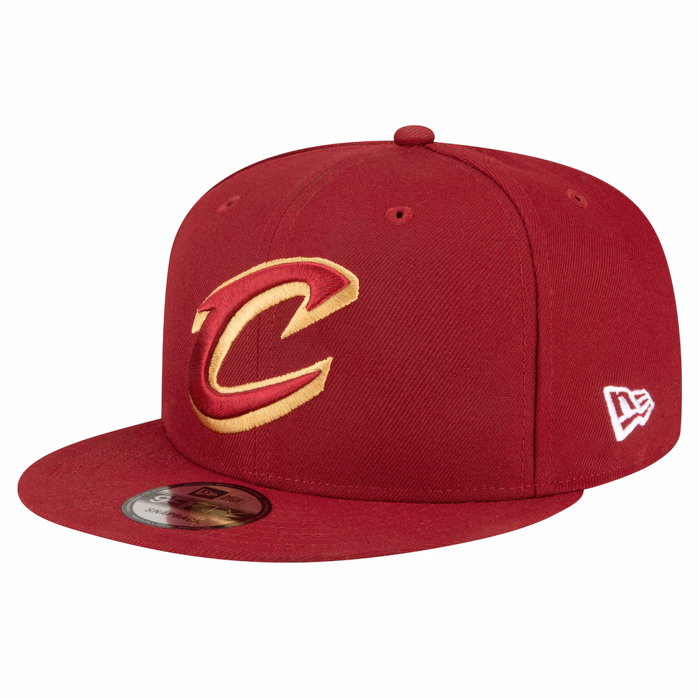 Three-quarter profile view of the New Era Cleveland Cavaliers wine 9FIFTY snapback hat featuring the C logo and New Era flag.