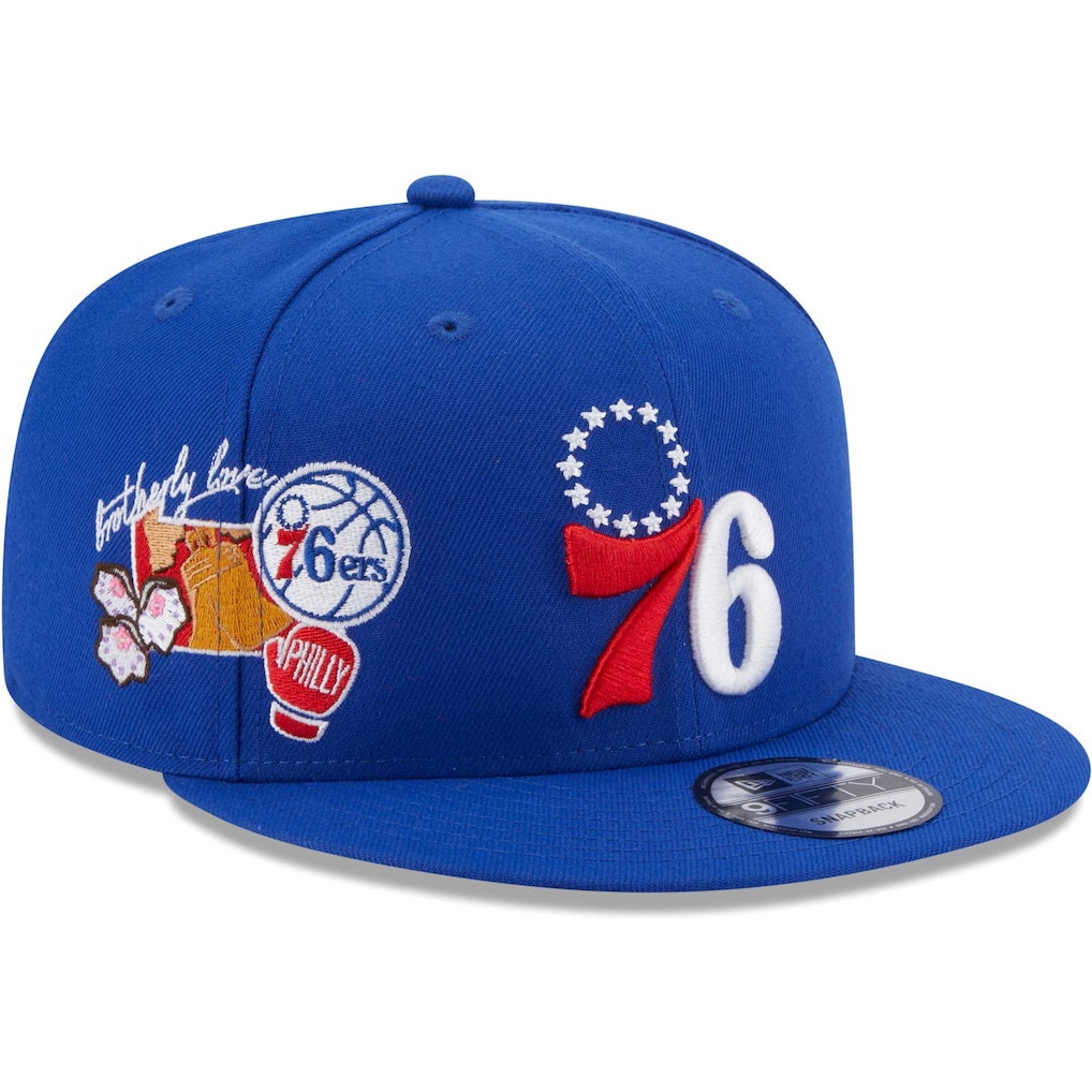 Right angled view of the New Era Philadelphia 76ers Royal 9FIFTY Snapback Hat highlighting the embroidered Brotherly Love, Liberty Bell, and Philly boxing glove side patches