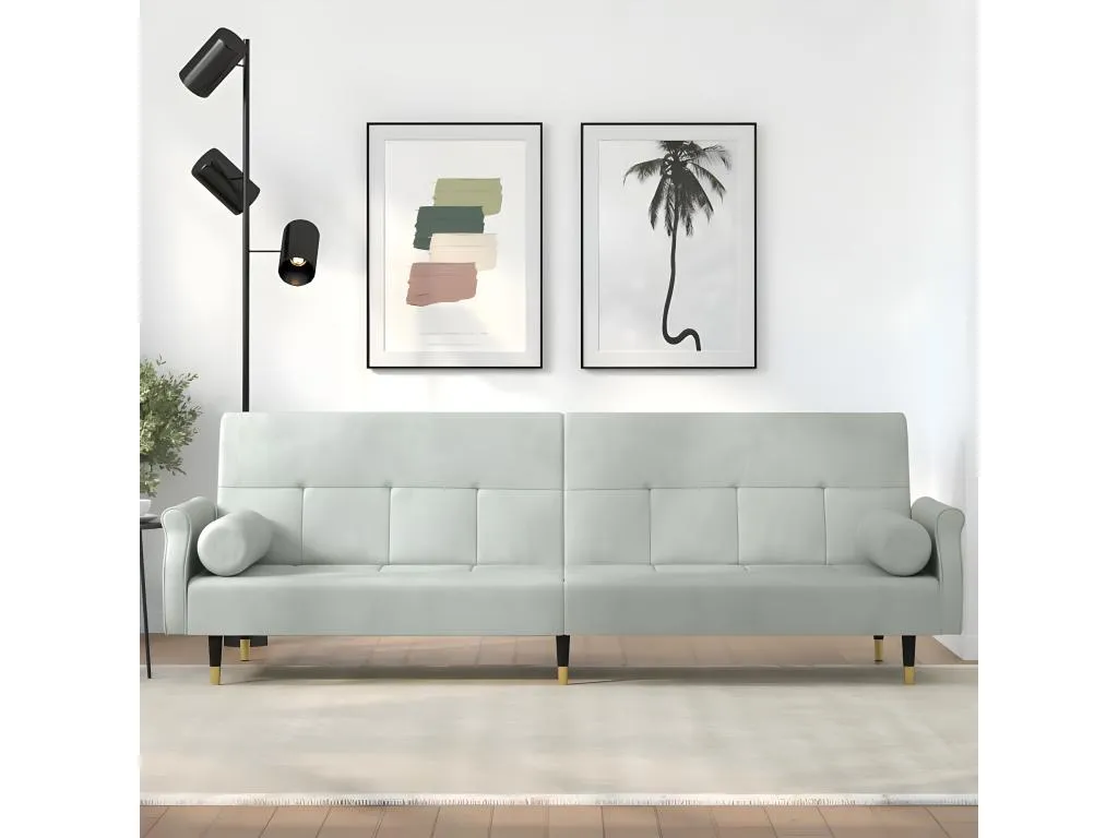 Sofá cama con cojines de terciopelo gris claro.