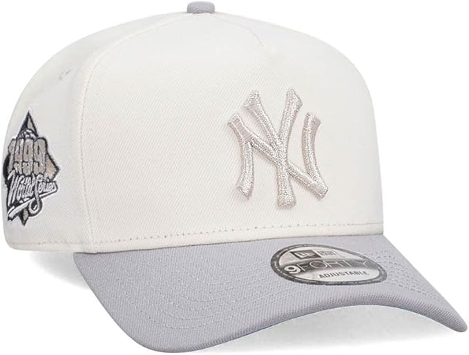 Front three-quarter view of the New Era New York Yankees 1999 World Series 9FORTY Snapback Hat showing the cream crown, grey visor, and raised NY logo.